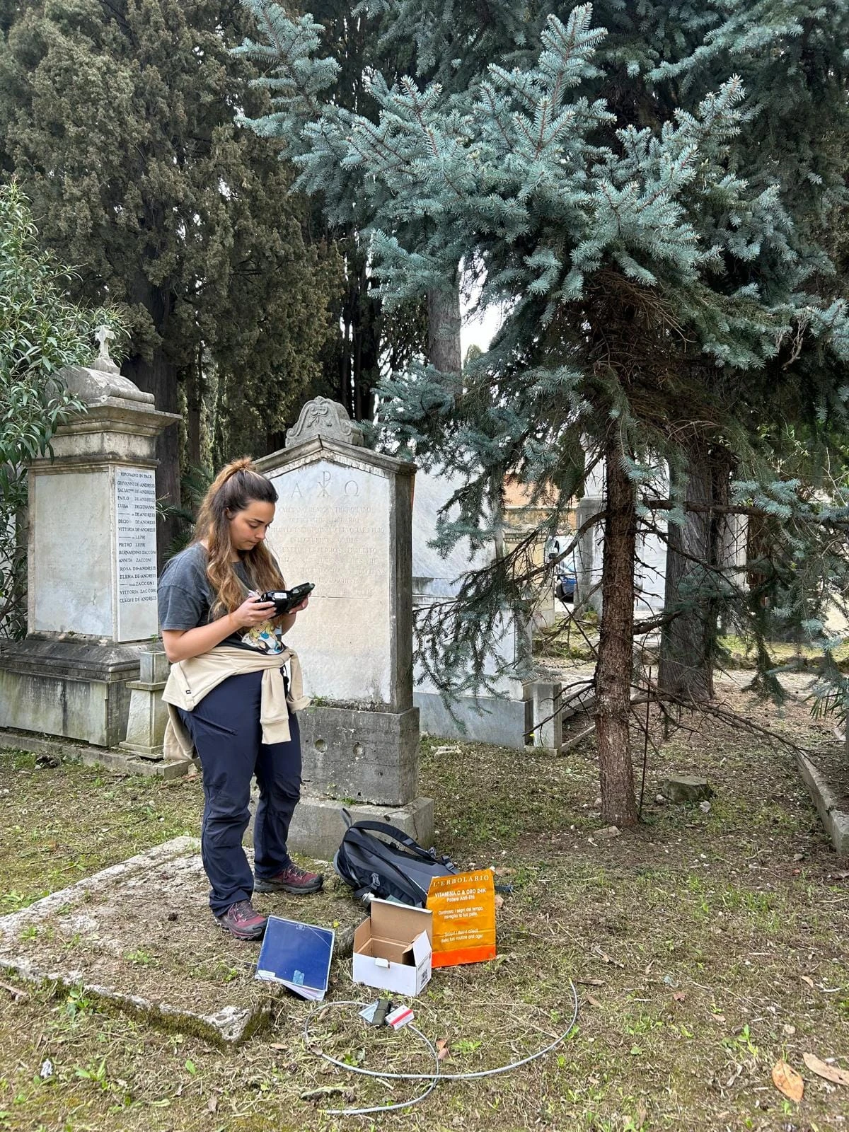 Laura checking monitoring equipment in a cemetery